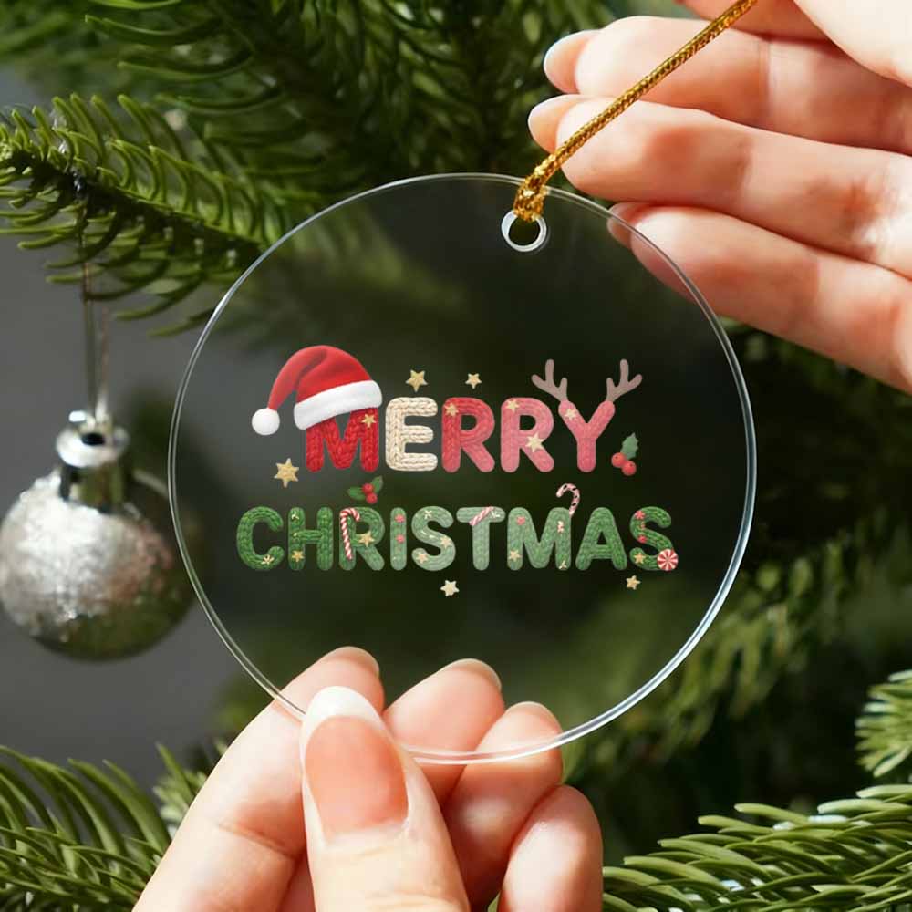 Clear Christmas ornament with 'Merry Christmas' text held by hands against a Christmas tree background