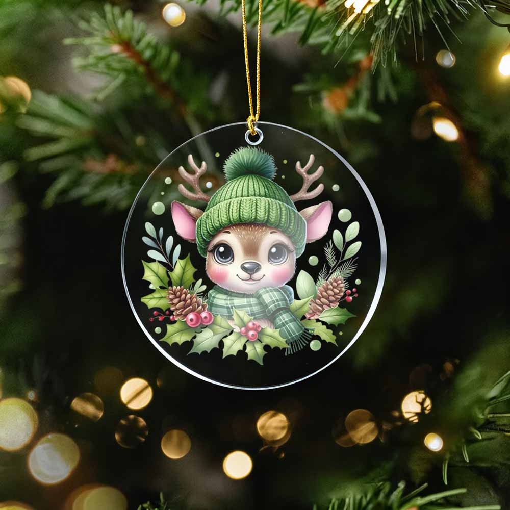 Christmas ornament with a cartoon deer wearing a green hat and scarf on a tree.
