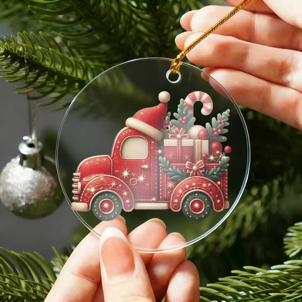 Red truck Christmas ornament held by a hand with a tree in the background