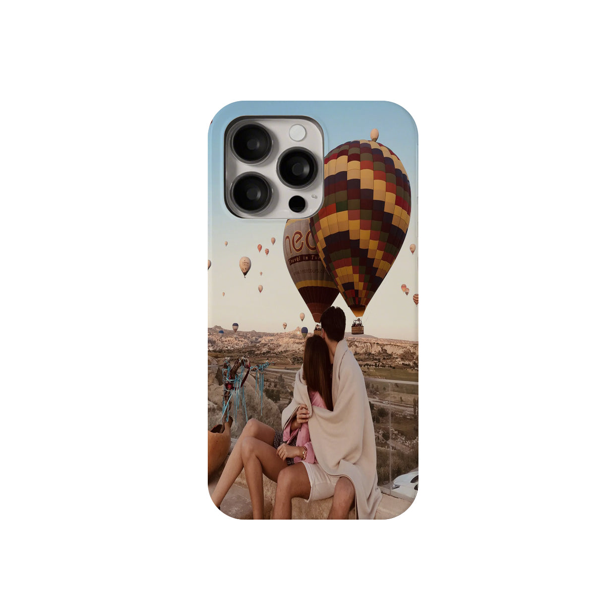 Phone case with a design of a couple under hot air balloons and a scenic background.