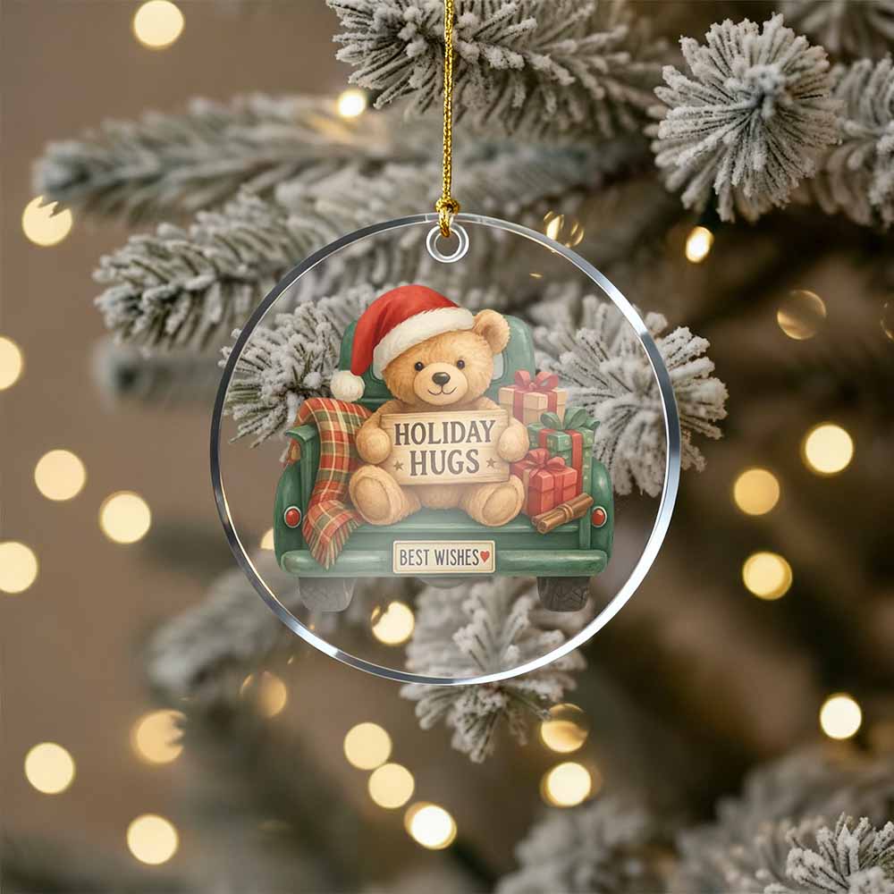Christmas ornament with a teddy bear in a sleigh and 'Holiday Hugs' text, hanging on a decorated tree.