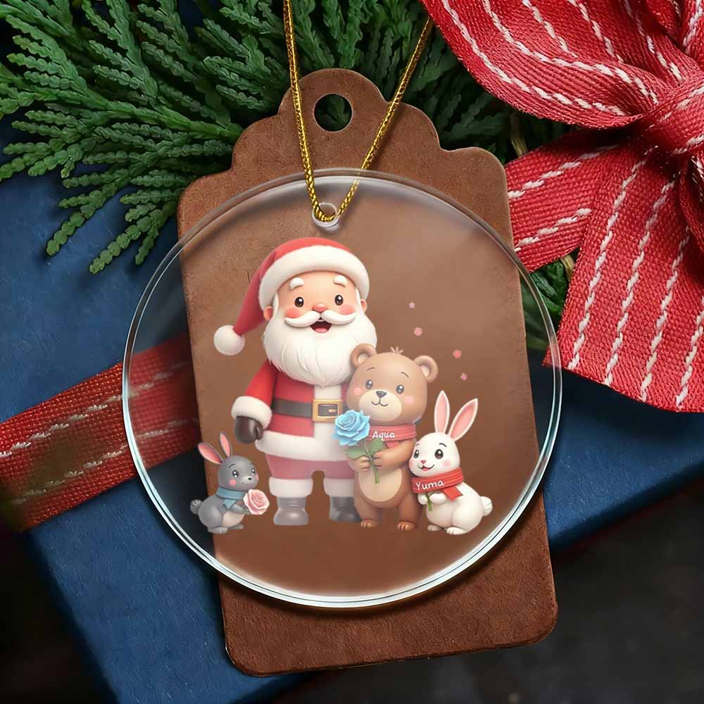 Christmas ornament with Santa Claus, teddy bear, and rabbit on a brown tag with greenery and red ribbon in the background.