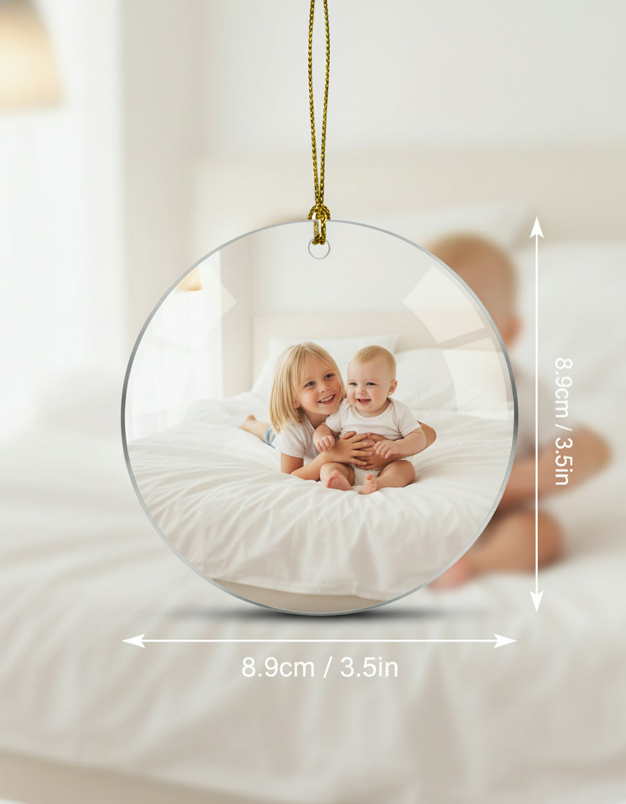 Round photo ornament with two children inside, hanging against a neutral background.